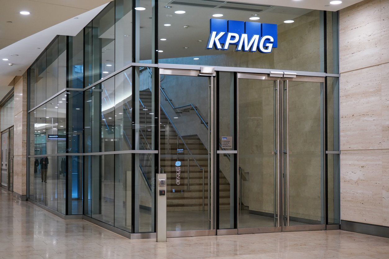 Синя вивіска KPMG біля входу в їхні офіси в Кенері-Ворф